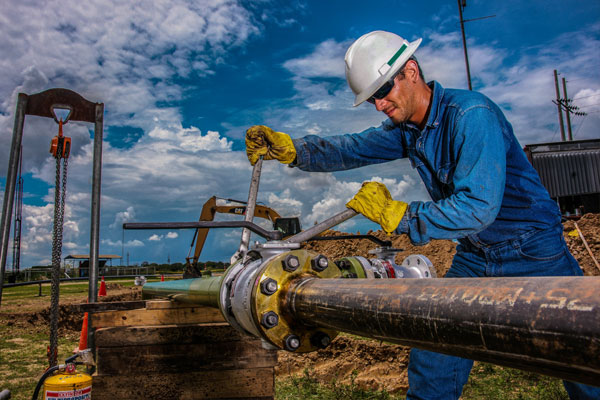 Operario industrial realizando mantenimiento en tubería con equipo de seguridad HSEQ - Fotografía de registro estratégico